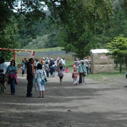 a group of people walking down a dirt road a group of people walking down a dirt road