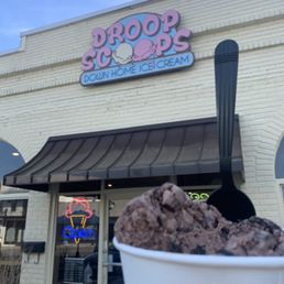 a hand holding a cup of ice cream