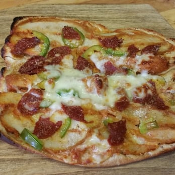 Frank's Pizza - a pepperoni pizza on a wooden cutting board - Pizza Near Me - Brooklyn, New York