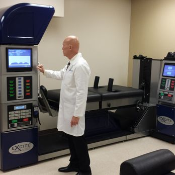 Wakeman Chiropractic - Dr. Peter Wakeman setting up another patient on the DRX9000C Spinal Decompression Machine - Chiropractors Near Me - Daytona Beach, Florida
