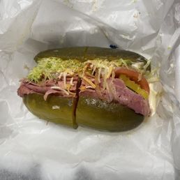 Yum Yum sandwich which is a pickle sandwich with corned beef, lettuce, tomato, cheese, mild peppers, sauce, and seasoning Yum Yum sandwich which is a pickle sandwich with corned beef, lettuce, tomato, cheese, mild peppers, sauce, and seasoning