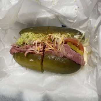 What's The Dill - Yum Yum sandwich which is a pickle sandwich with corned beef, lettuce, tomato, cheese, mild peppers, sauce, and seasoning - Delis Near Me - Detroit, Michigan What's The Dill - Yum Yum sandwich which is a pickle sandwich with corned beef, lettuce, tomato, cheese, mild peppers, sauce, and seasoning - Delis Near Me - Detroit, Michigan