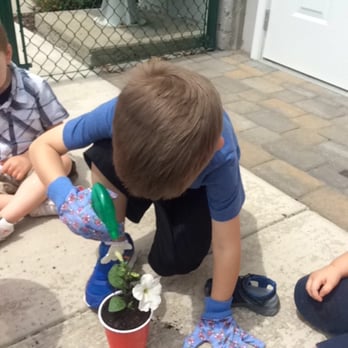 Gloworms Academy - Watering the flowers after they have been planted - Child Care & Day Care Near Me - Pittsburgh, Pennsylvania