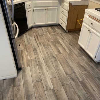 KGMC’s Tile - a kitchen with white cabinets and wood flooring - Flooring Near Me KGMC’s Tile - a kitchen with white cabinets and wood flooring - Flooring Near Me