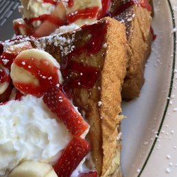 a plate of french toast with strawberries and bananas