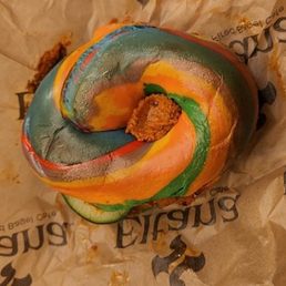Rainbow bagel with red pepper walnut hummus