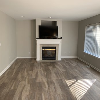 Service Pros & Asbestos - a living room with wood floors and a fireplace - Damage Restoration Near Me Service Pros & Asbestos - a living room with wood floors and a fireplace - Damage Restoration Near Me