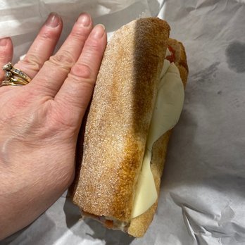 Pizza Booyah - The sandwich half that was $9.00 whole. My hand as a size comp. I have a relatively small hand - Pizza Near Me - Willoughby, Ohio