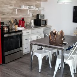 Adorable kitchen, fully stocked with plates, glasses, silverware and complimentary hand sanitizer and disinfectant spray on the table.