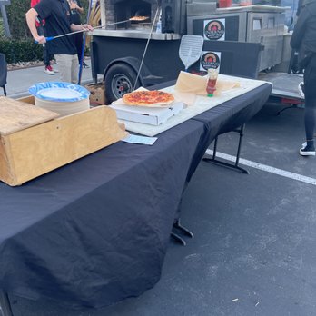 Inferno Woodfired Kitchen - a table with pizzas on it - Food Trucks Near Me