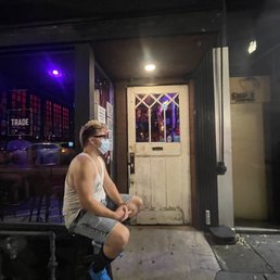 a man sitting on a stool in front of a store