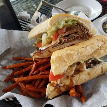 Cafe Navarre - Dirty bird poboy that's dressed to the nines and accompanied by crispy sweet potato fries. - Sandwiches Near Me - New Orleans, Louisiana
