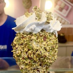 Small vanilla ice cream with pistachio topping and cream