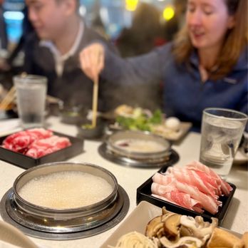Spring Shabu-Shabu - a group of people sitting at a table with food - Japanese Near Me - Flushing, New York
