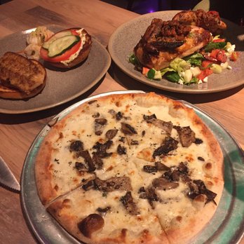 Moku Kitchen - Fresh Island Fish Sandwich looking sorry in the back on an empty plate, no side. Rotisserie Chicken, Wild Hamakua Mushroom Pizza - Cocktail Bars Near Me - Honolulu, Hawaii