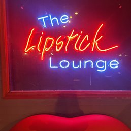 a neon sign with the word lipstick lounge
