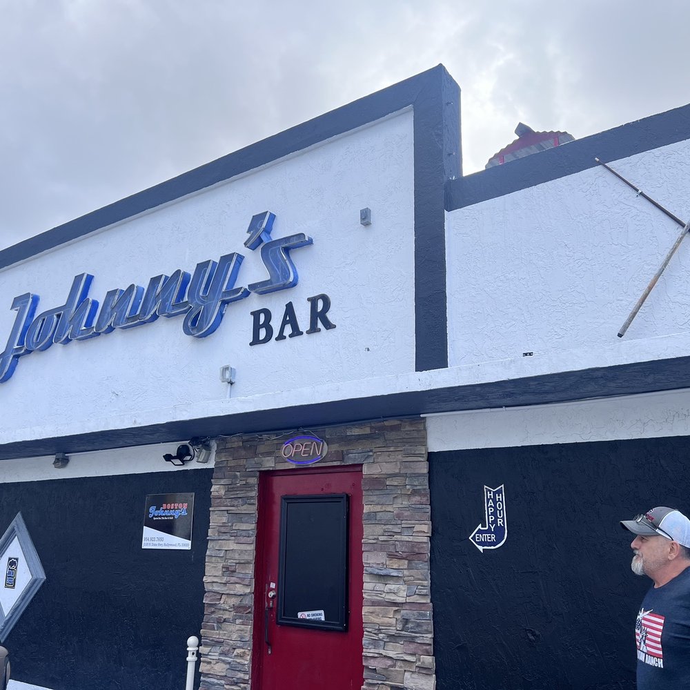 a man standing in front of a bar a man standing in front of a bar