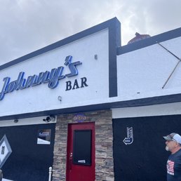 a man standing in front of a bar
