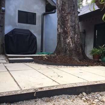 Austin Drainage + Landscape Development - Courtyard with limestone pavers, 4-6" steel, 3/8" limestone rock, Colorado River Rock for drainage, and some very gnarly roots. - Landscaping Near Me - Austin, Texas