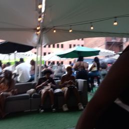 a group of people sitting under a tent a group of people sitting under a tent