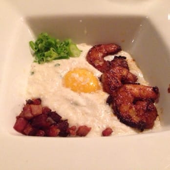 District Table and Bar - Blackened shrimp and grits with a free range egg yolk and bacon. - New American Near Me - Stuart, Florida