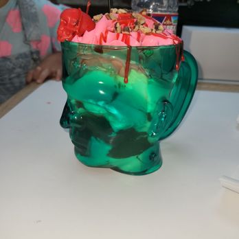 The Grim Bakers - Frankensundy Soft serve Sundae with whipped cream toasted nuts, red ganache, and a skull cherry in a Frankenstein cup w/shovel spoon. - Bakeries Near Me - San Antonio, Texas