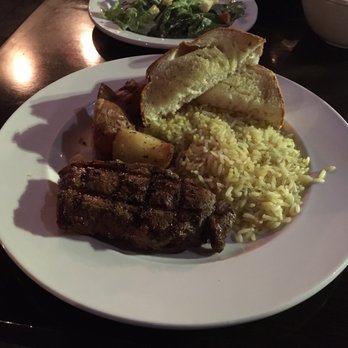 LA Grill & Bistro - New York Steak with sides brown rice, garlic bread, and potato wedges. - American Near Me - Richmond, British Columbia