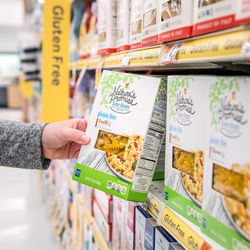 Tight shot of customer picking up a Nature's Promise item off the shelf.