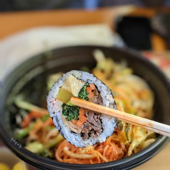 Sirok - a person holding chopsticks over a bowl of food - Korean Near Me - Chantilly, Virginia