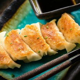 a plate of dumplings with chopsticks a plate of dumplings with chopsticks