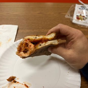 The Flying Pizza - a hand holding a half eaten pizza - Pizza Near Me - Fairborn, Ohio