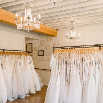 Cleo Bridal - Wedding dresses hanging in white room with chandeliers. - Bridal Near Me - O'Fallon, Missouri Cleo Bridal - Wedding dresses hanging in white room with chandeliers. - Bridal Near Me - O'Fallon, Missouri