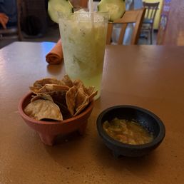 Chips, salsa, and a cucumber drink.