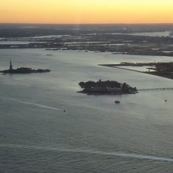 One World Observatory - Statue of Liberty and Ellis Island at sunset - Observatories Near Me - New York, New York One World Observatory - Statue of Liberty and Ellis Island at sunset - Observatories Near Me - New York, New York