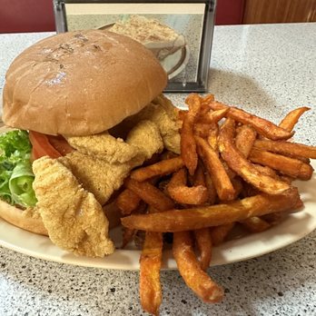Lone Star Grill - Fried catfish sandwich with lettuce, tomato and tartar sauce on a toasted bun with a side of sweet potato fries. - American Near Me - Benbrook, Texas