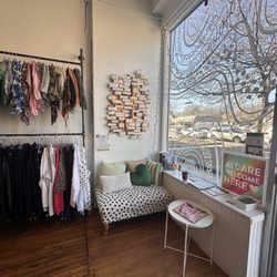 Cake Plus-Size Resale - Interior of the store featuring a comfortable sitting area, reading material, and flyers