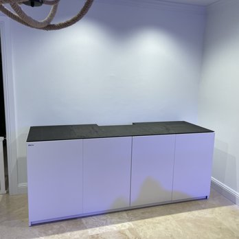 We Go Assemble - Finished cabinet. - A white cabinet with a dark countertop is positioned against a white wall in a room with beige flooring. - Furniture Assembly Near Me - Miami, Florida