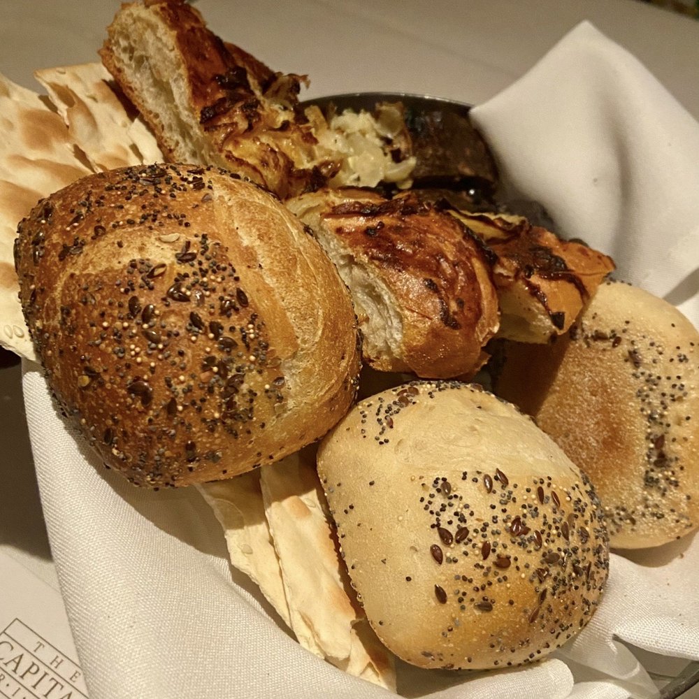 The Capital Grille - Complimentary bread basket-- ciabatta, pumpernickel bread, raisin currant bread, onion bread, and lavash crackers - Steakhouses Near Me - Burbank, California The Capital Grille - Complimentary bread basket-- ciabatta, pumpernickel bread, raisin currant bread, onion bread, and lavash crackers - Steakhouses Near Me - Burbank, California