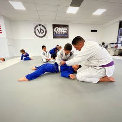 One Legacy Training Center - Coach Christian helping students with the technique of the day