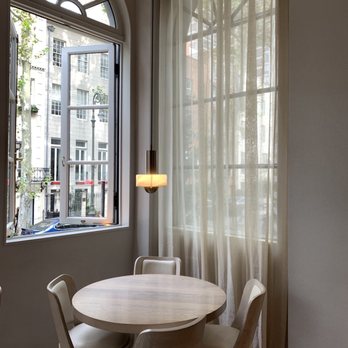 JoJo - a table and chairs in front of a window - New American Near Me - New York, New York JoJo - a table and chairs in front of a window - New American Near Me - New York, New York