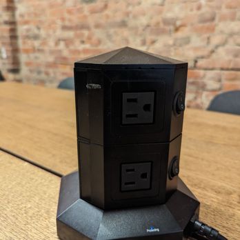 Cosette - a black power strip on a wooden table - Coffee & Tea Near Me - Toronto, Ontario