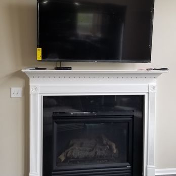 Entec Electric - 65" Television hung above mantle by Entec Electric. Secured via bracket with tilt and adjust. Wires hidden. - Electricians Near Me - Cincinnati, Ohio