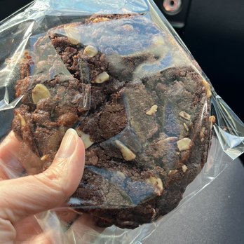 Coco's Cafe - a hand holding a chocolate cookie - Coffee & Tea Near Me - Jasper, Alberta