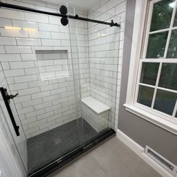 Sun Shore Construction - Modern shower design with sleek glass doors, subway tiles, and a built-in bench. Clean, stylish, and functional! #BathroomUpgrade