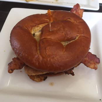 Chomp - Sriracha Chicken Club: Grilled Chicken, Bacon, Sriracha Mayo, Tomato, Chipotle Caramelized Onions, Guacamole, Lettuce, on a Pretzel Bun. - American Near Me - Rochester, Michigan