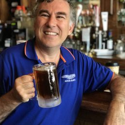 a man in a blue polo shirt holding a glass of beer a man in a blue polo shirt holding a glass of beer