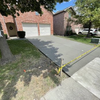 Precision contractor - a concrete driveway being laid in front of a house - Roofing Near Me Precision contractor - a concrete driveway being laid in front of a house - Roofing Near Me