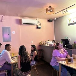 Small interior with about five tables and one bar stool seating
