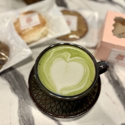Sacred Grounds Coffee - Matcha tea with oat milk. Different cookies and cinnamon roll.