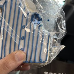 Hair on the white layer of icing, pinned with the blue layer. Tells me this happened during the decorative process. Hair on the white layer of icing, pinned with the blue layer. Tells me this happened during the decorative process.